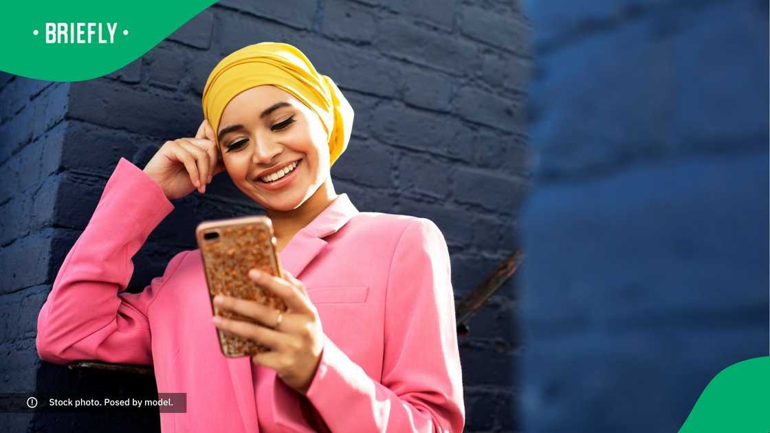 A woman smiling at her phone. A woman smiling at her phone.