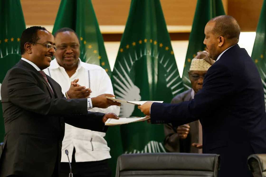 Ethiopian government representative Redwan Hussien Rameto, left, and Tigrayan rebel spokesman Getachew Reda, right, exchange documents after signing the agreement in Pretoria Ethiopian government representative Redwan Hussien Rameto, left, and Tigrayan rebel spokesman Getachew Reda, right, exchange documents after signing the agreement in Pretoria