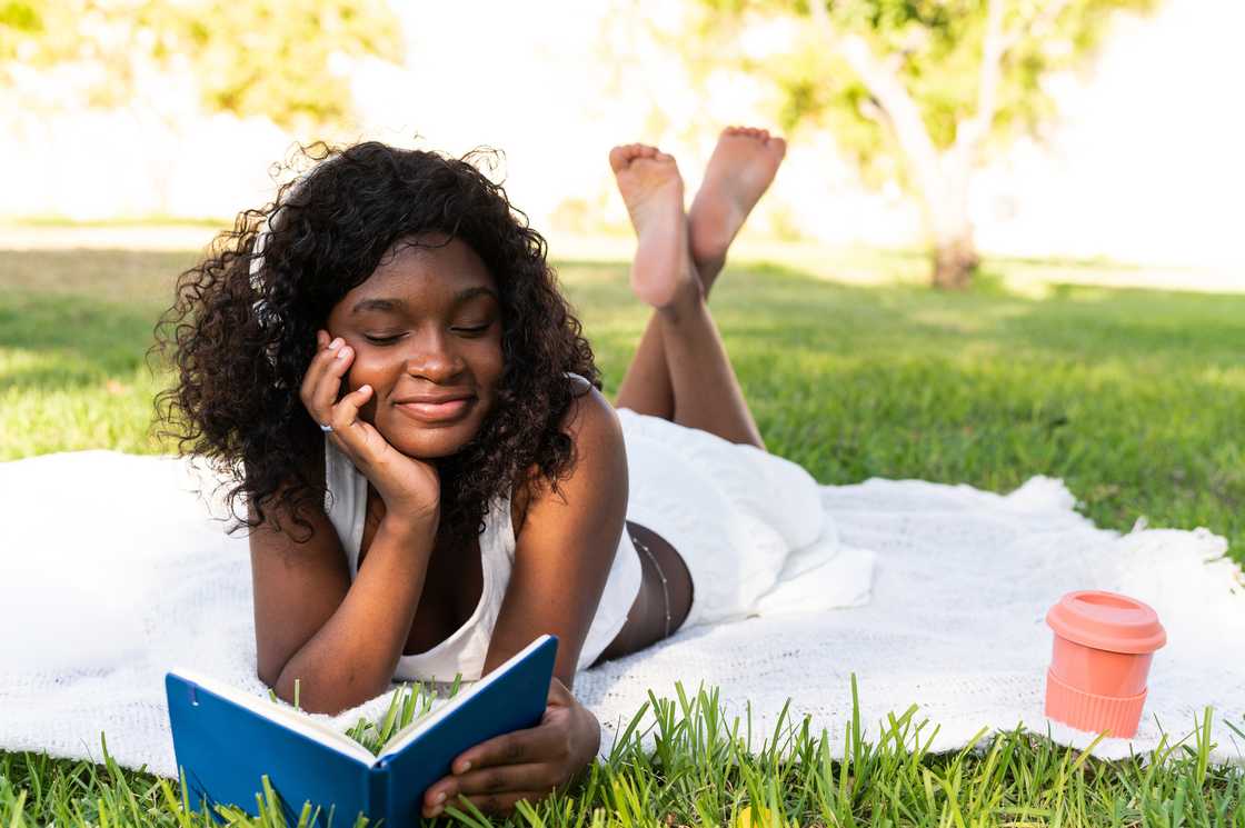 Girl studying happily under a tree after school.