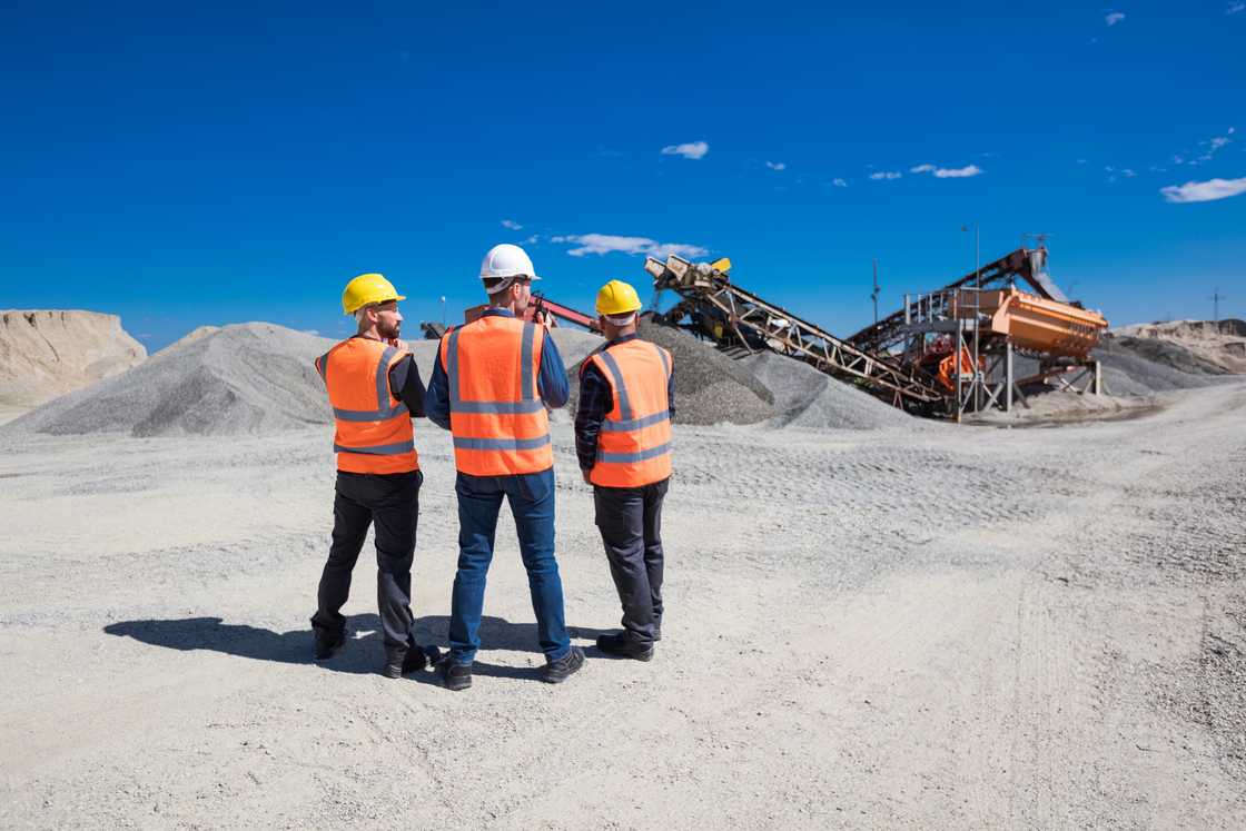 Open-pit mine engineer and workers at site.