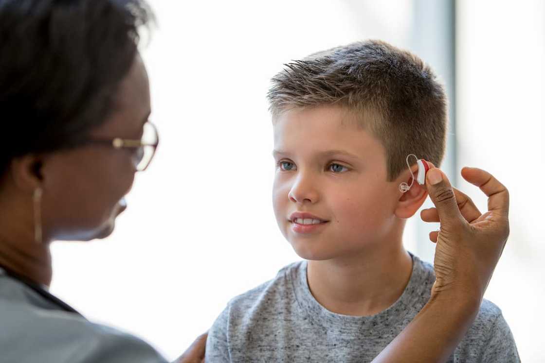 A young boy wearing hearing aid A young boy wearing hearing aid