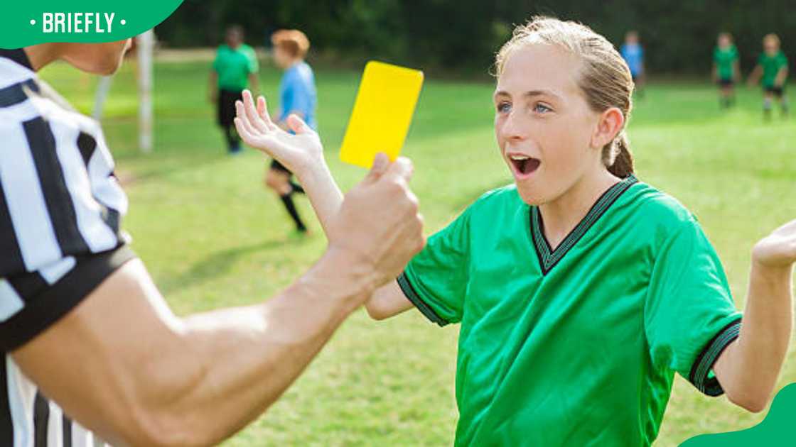 Female teenage soccer player getting a yellow card