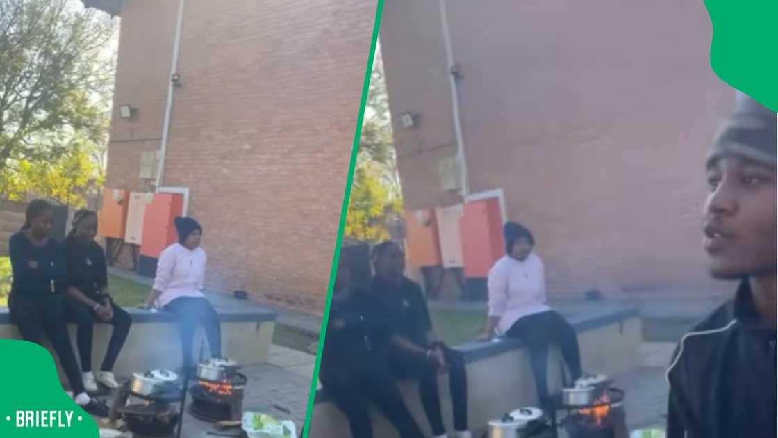 VUT students in a campus residence, hunched over an open wood fire on the floor, preparing their meals
