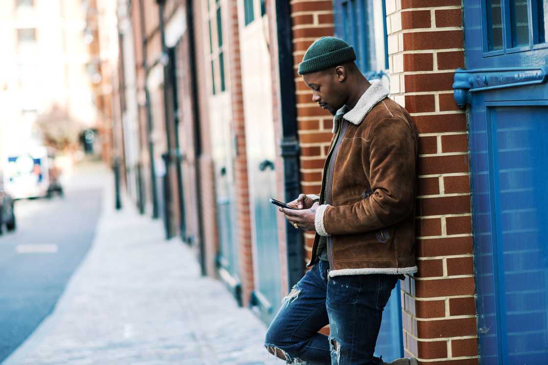 A young man checking on his phone on empty streets