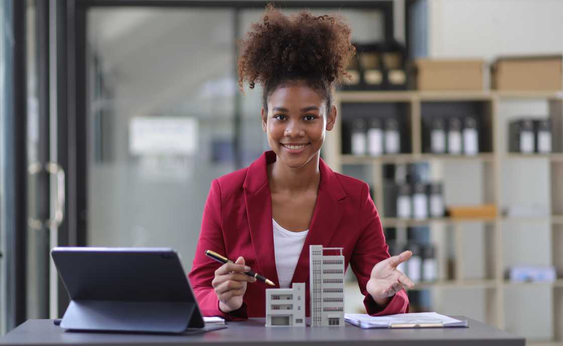 A real estate agent presents residential building and house sale contracts to sign.