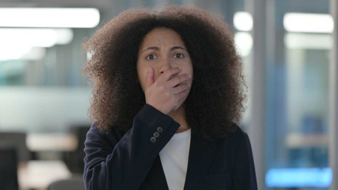 A terrified woman holding her mouth