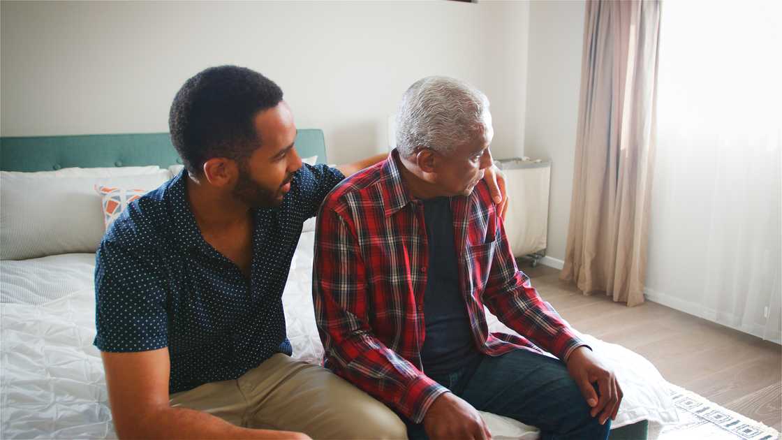 Adult son comforting senior father Adult son comforting senior father