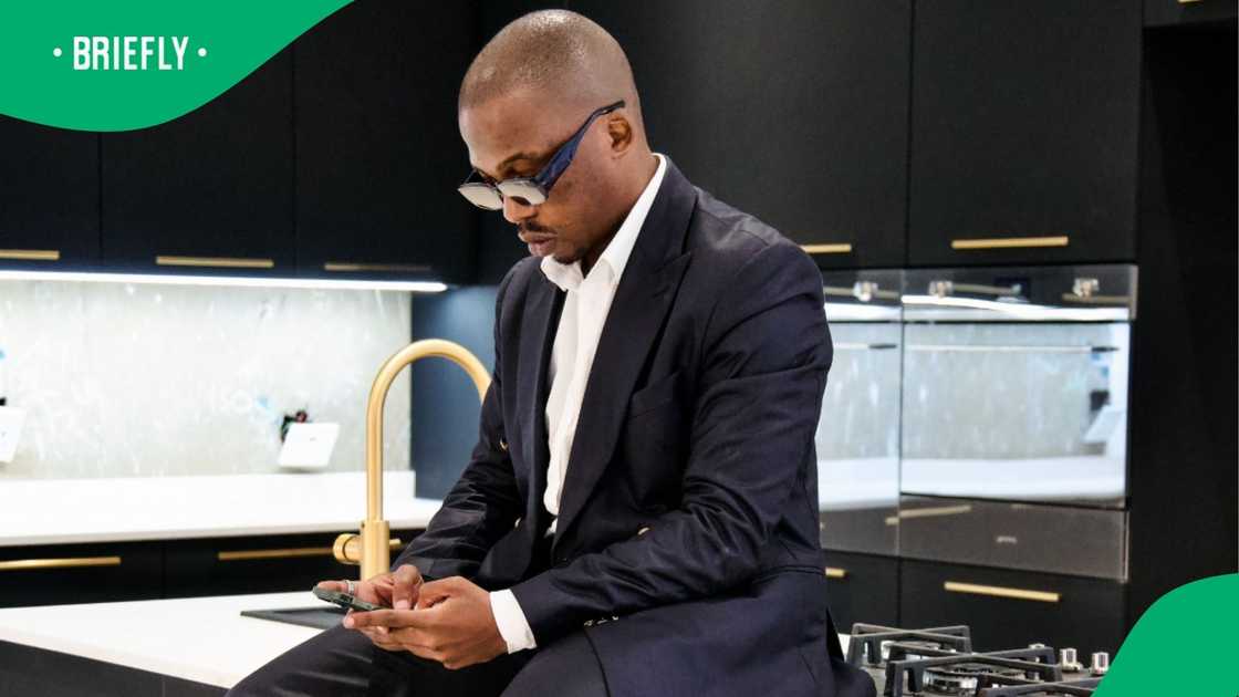 A man captured on TikTok typing on his phone in the kitchen A man captured on TikTok typing on his phone in the kitchen