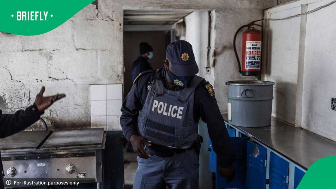 South African policemen search a dwelling at the Nguni Hostels in Vosloorus, on July 27, 2021during a joint operation between the South Africa Police Service (SAPS) and the South Africa National Defence Forces (SANDF)