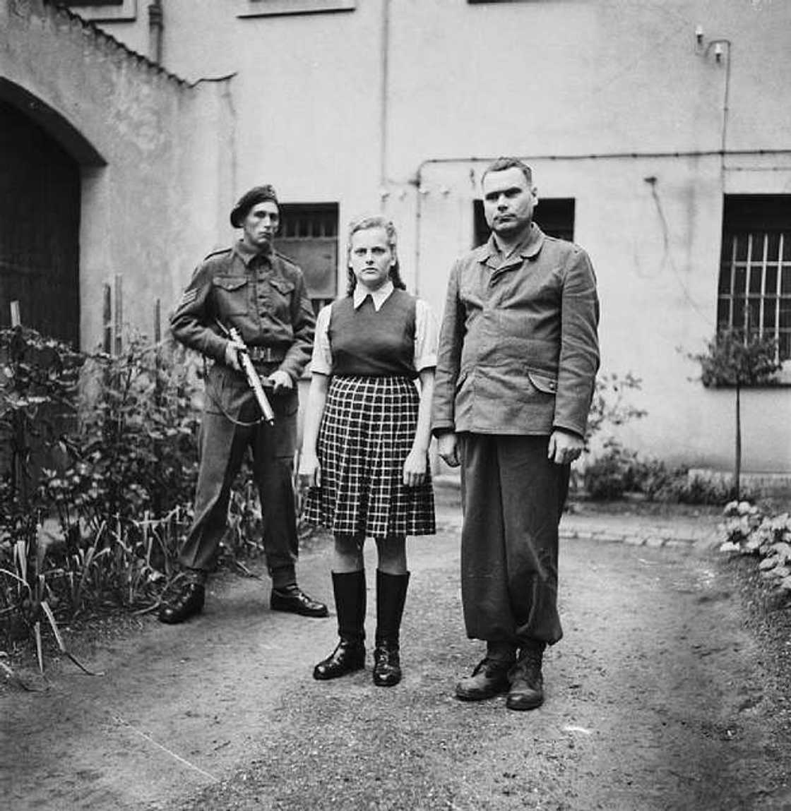 Irma Grese standing in a courtyard alongside Josef Kramer Irma Grese standing in a courtyard alongside Josef Kramer
