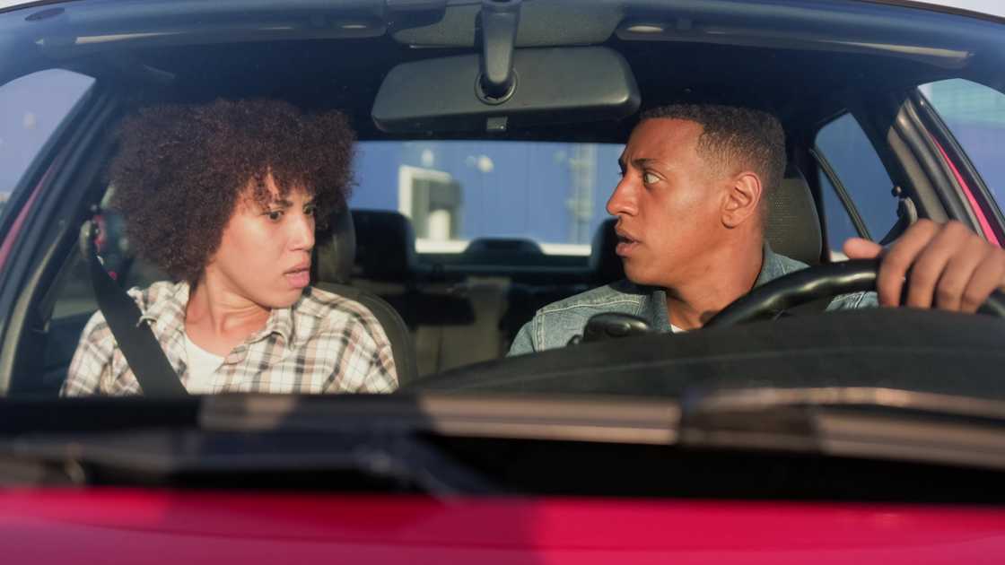 A woman shouting at man, sitting in automobile