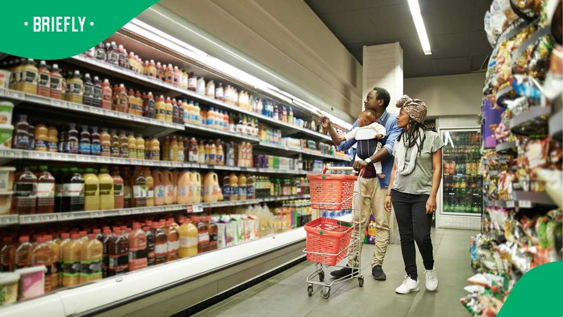 A shot of a couple grocery shopping with their baby A shot of a couple grocery shopping with their baby