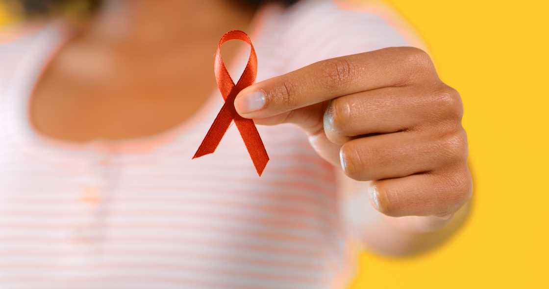 A women holds out a red ribbon for AIDS awareness. The HIV rates among Gauteng's older residents has raised questions.