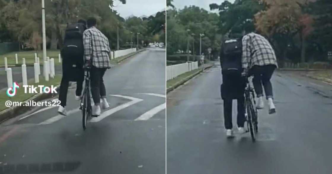 Men in Stellenbosch ride bike as one person Men in Stellenbosch ride bike as one person