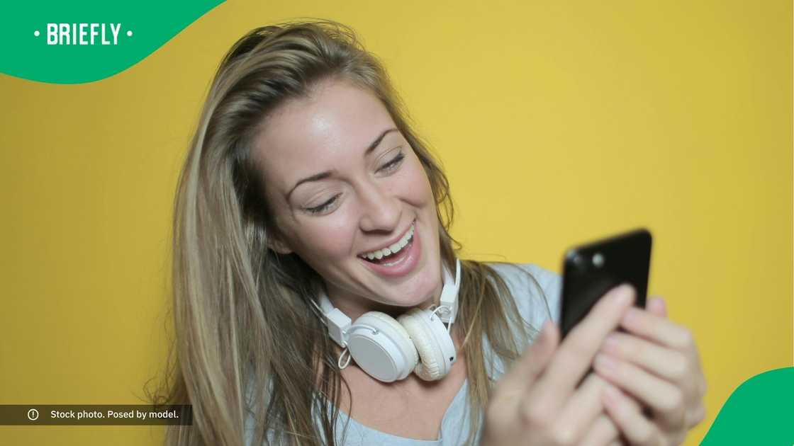 A woman laughing at her phone. A woman laughing at her phone.