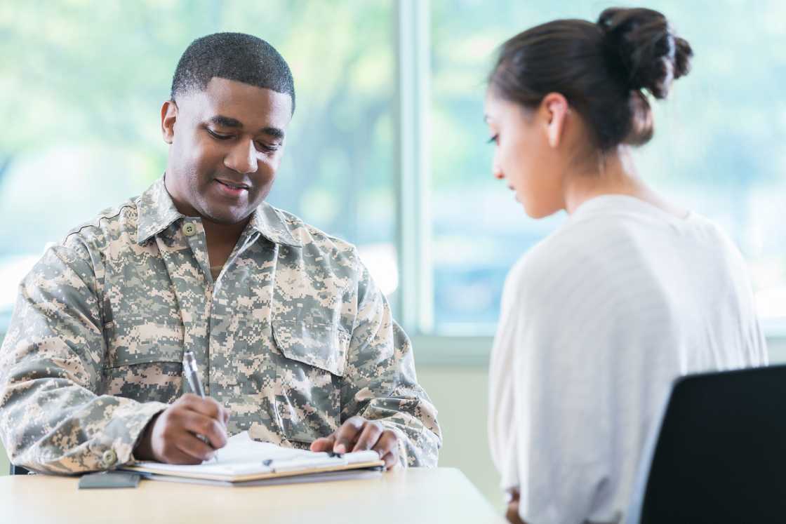 Security personell listening as he records on paper