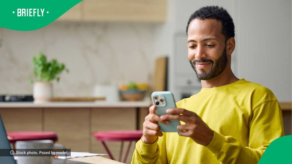 A man smiling at his phone.