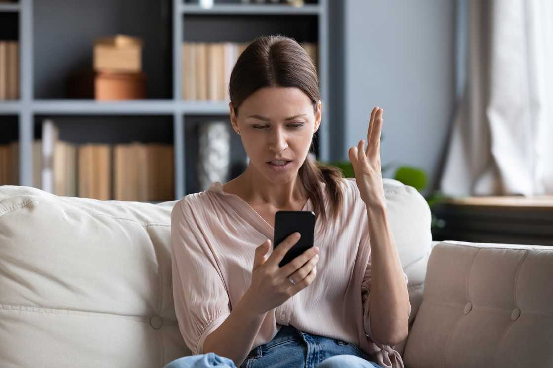 An upset woman looking at her phone. An upset woman looking at her phone.