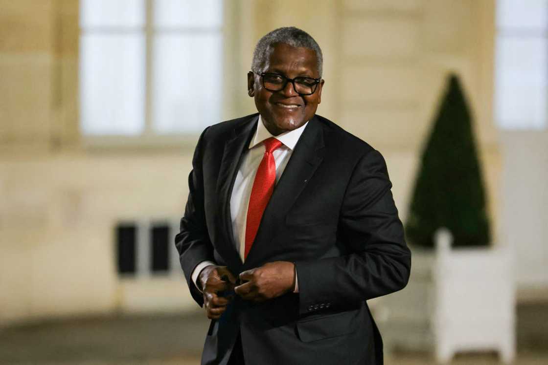 Aliko Dangote in a black a white suit with a red tie arriving for a dinner in honour of the President of Nigeria, at the Elysee palace in Paris