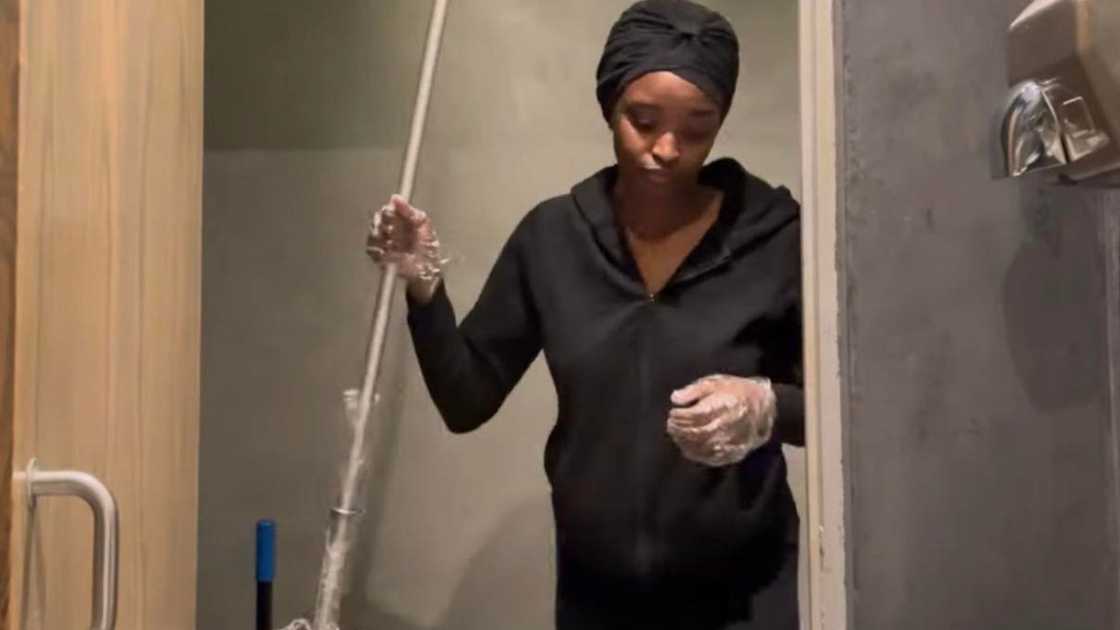 Phindi holding a mop before finding success abroad