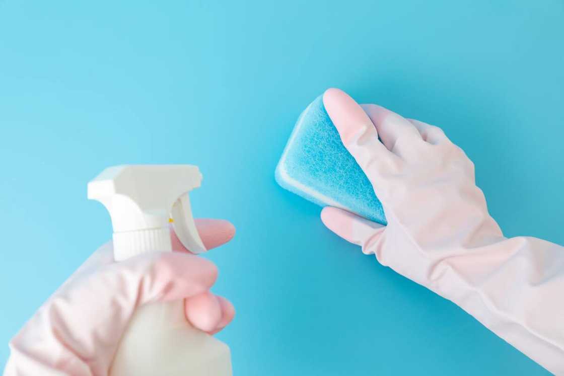 A person spraying alcohol on a sponge