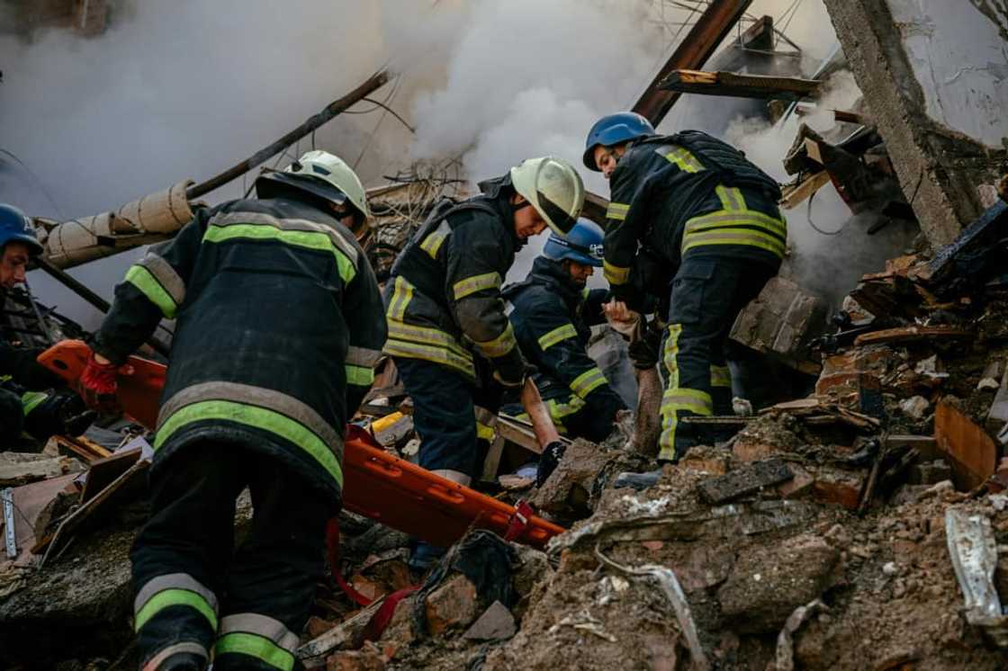 Ukrainian firefighters remove the body of a civilian killed after a strike in Zaporizhzhia