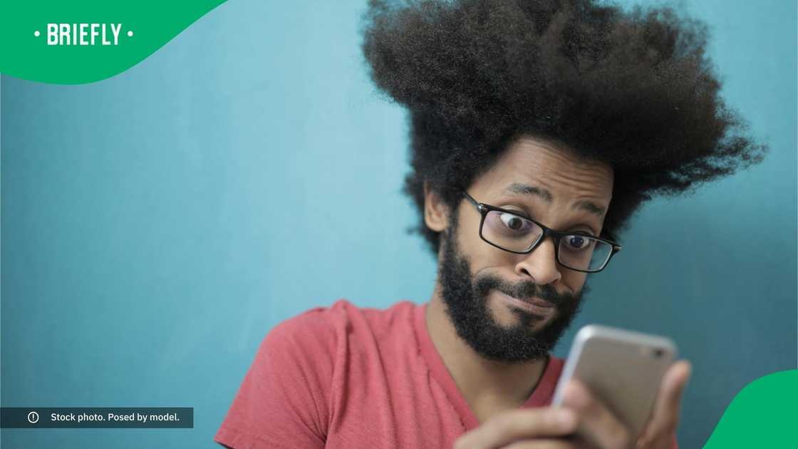 A stunned man looking at his phone.