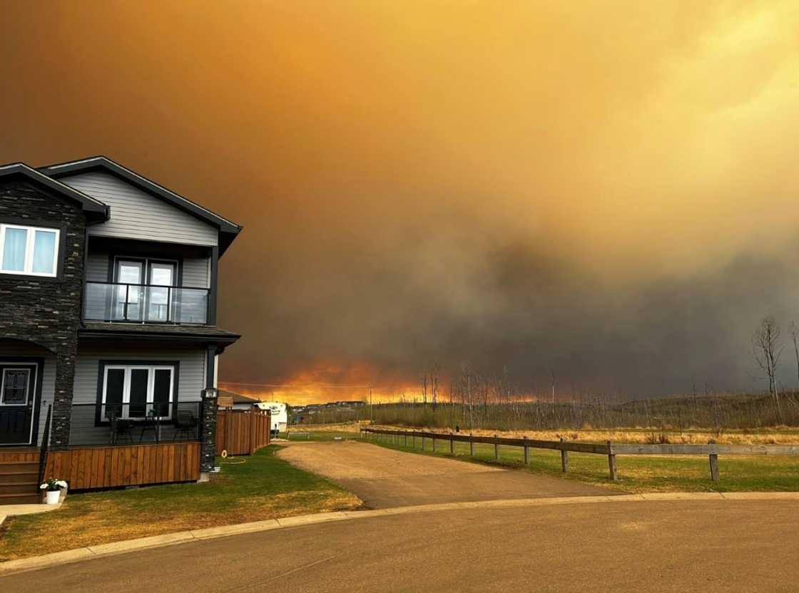 This handout image courtesy of Kosar shows smoke and flames from the fire in Fort McMurray as residents from the Abasand Heights neighborhood evacuate This handout image courtesy of Kosar shows smoke and flames from the fire in Fort McMurray as residents from the Abasand Heights neighborhood evacuate