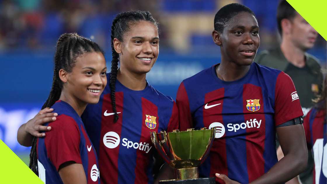 Asisat Oshoala and Vicky Lopez lifting a trophy for Barcelona in 2023.