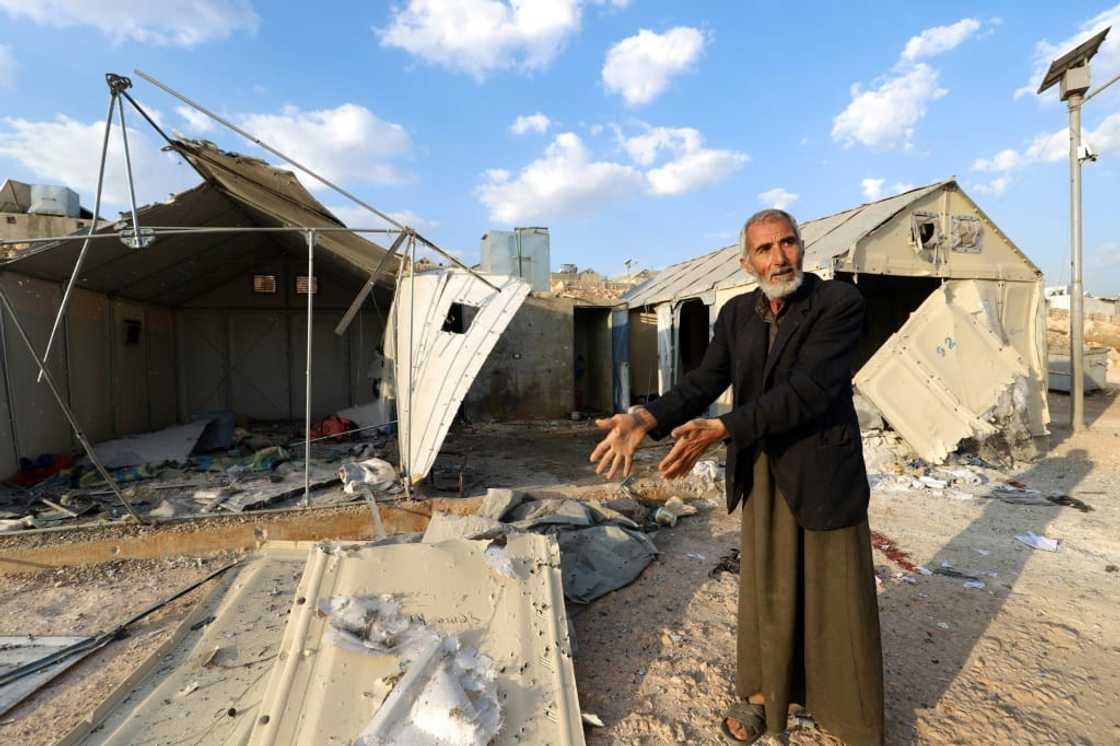 A man shows damage caused by the deadly rocket strikes