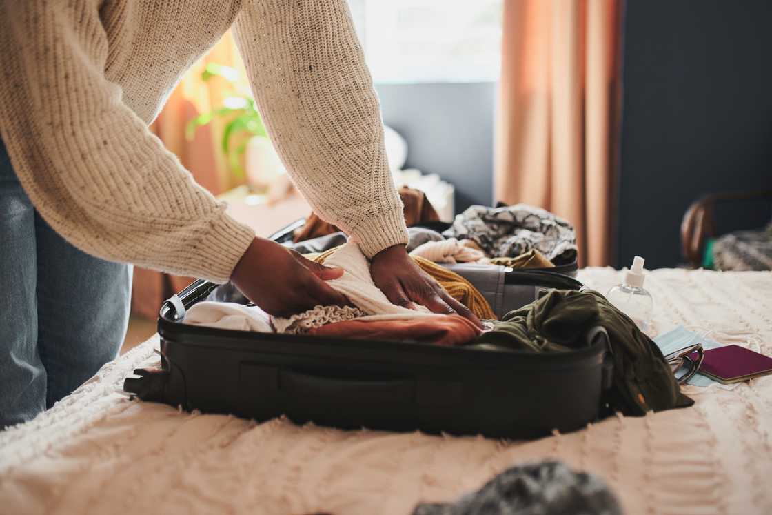 A woman is packing a suitcase