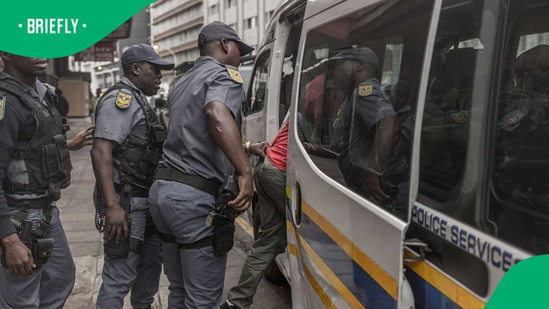 Members of the South African Police Service (SAPS) detain a suspected undocumented foreign national during a stop-and-search operation in central Durban on June 29, 2026