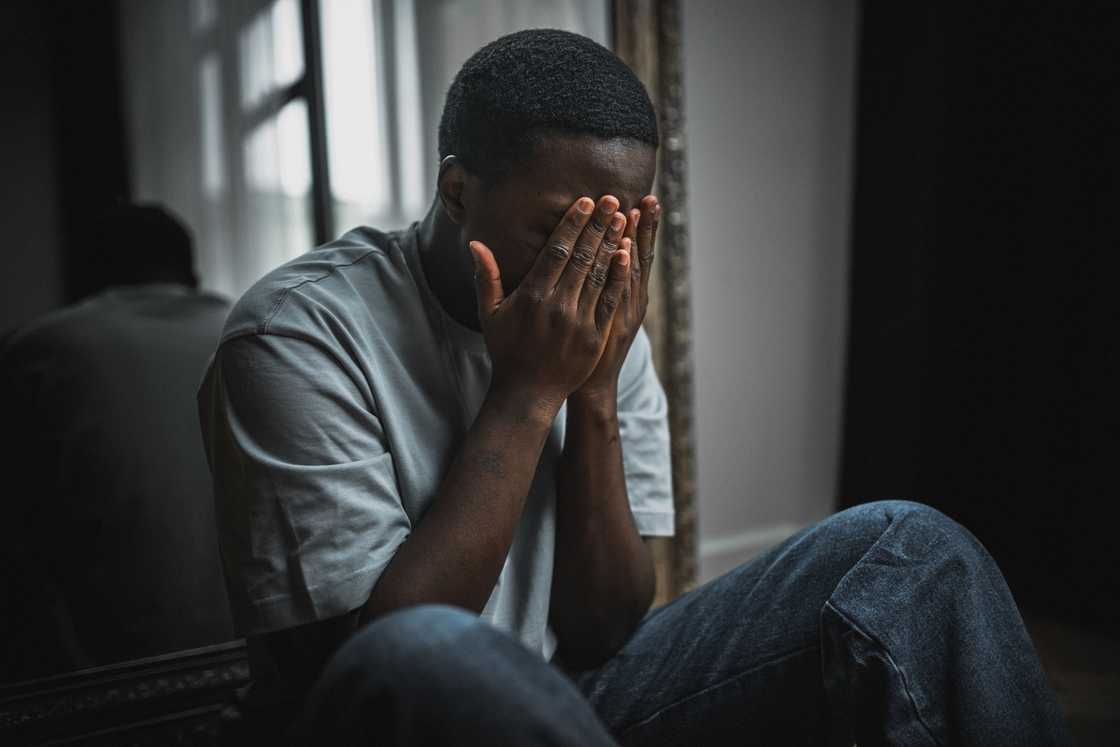 A stressed man sitting in a dark room