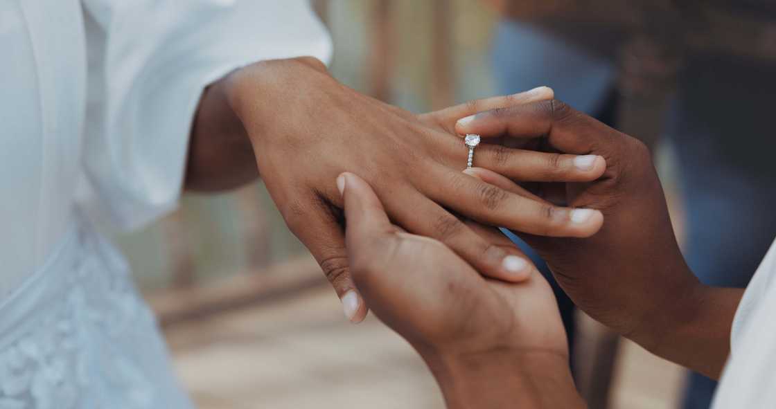A man puts a ring on his partner