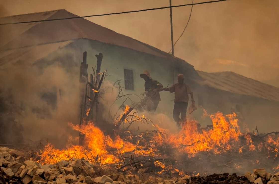Two men evacuate from a village as forest fires rage near the Moroccan city of Ksar el-Kebir on Thursday Two men evacuate from a village as forest fires rage near the Moroccan city of Ksar el-Kebir on Thursday