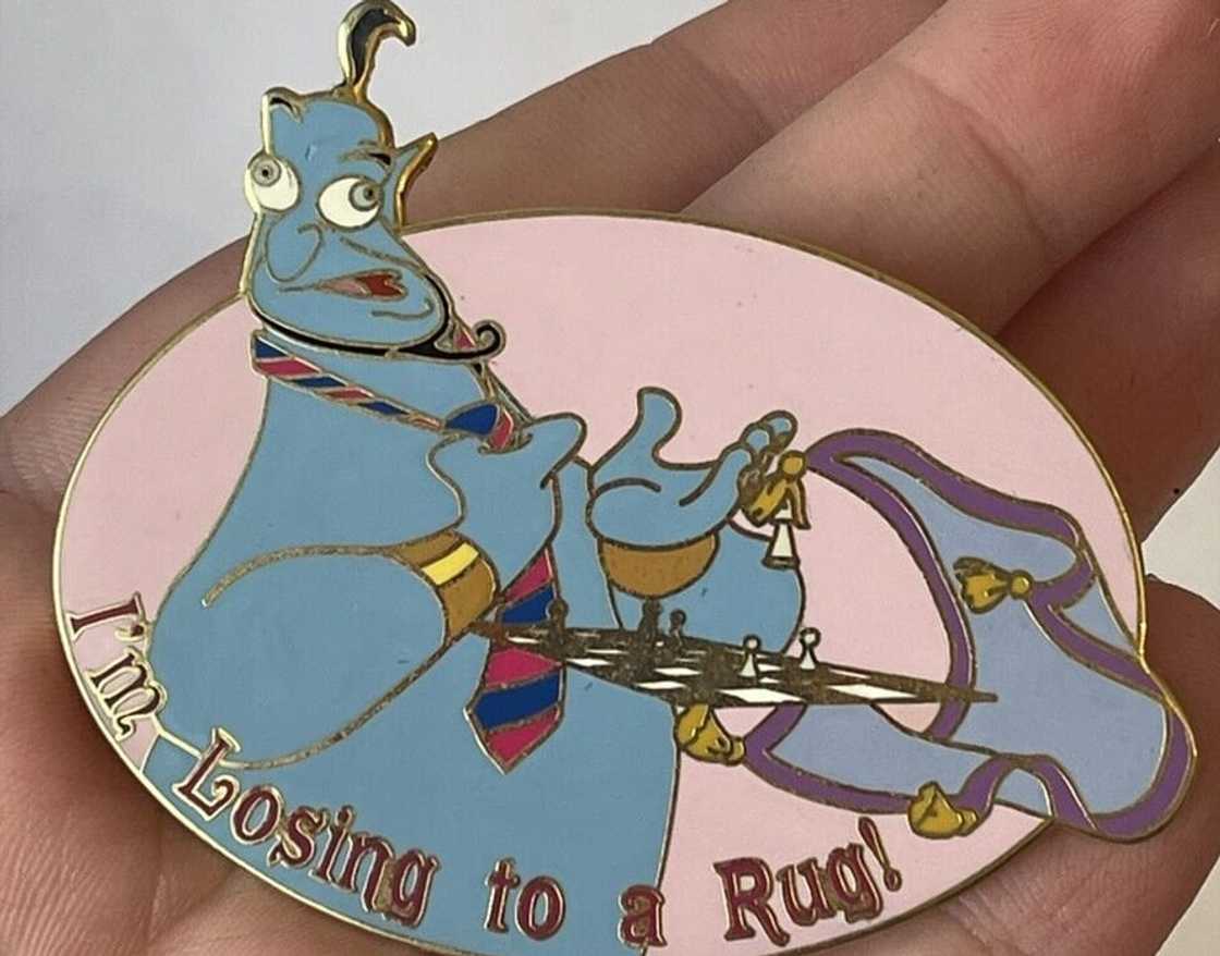 A person holding the Disney Auction Aladdin Genie Pin A person holding the Disney Auction Aladdin Genie Pin