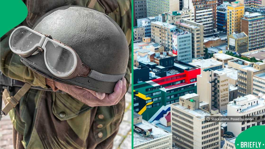 A soldier held a vintage military motorcycle helmet fitted with goggles