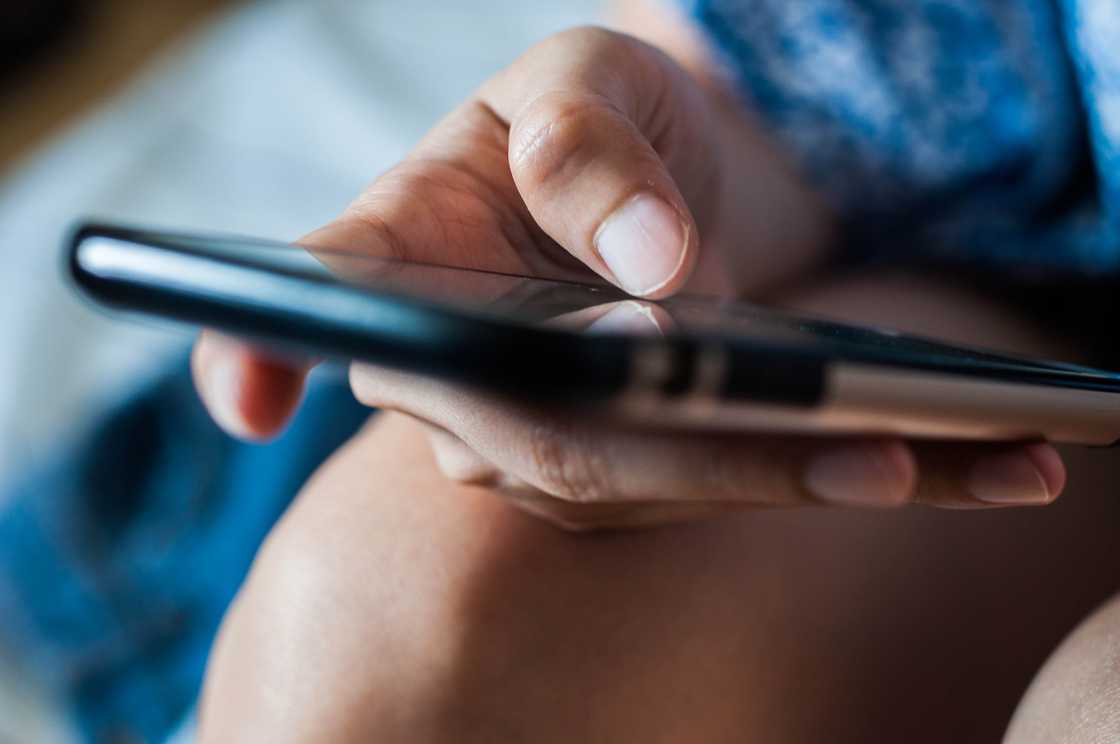 A woman typing on her phone.