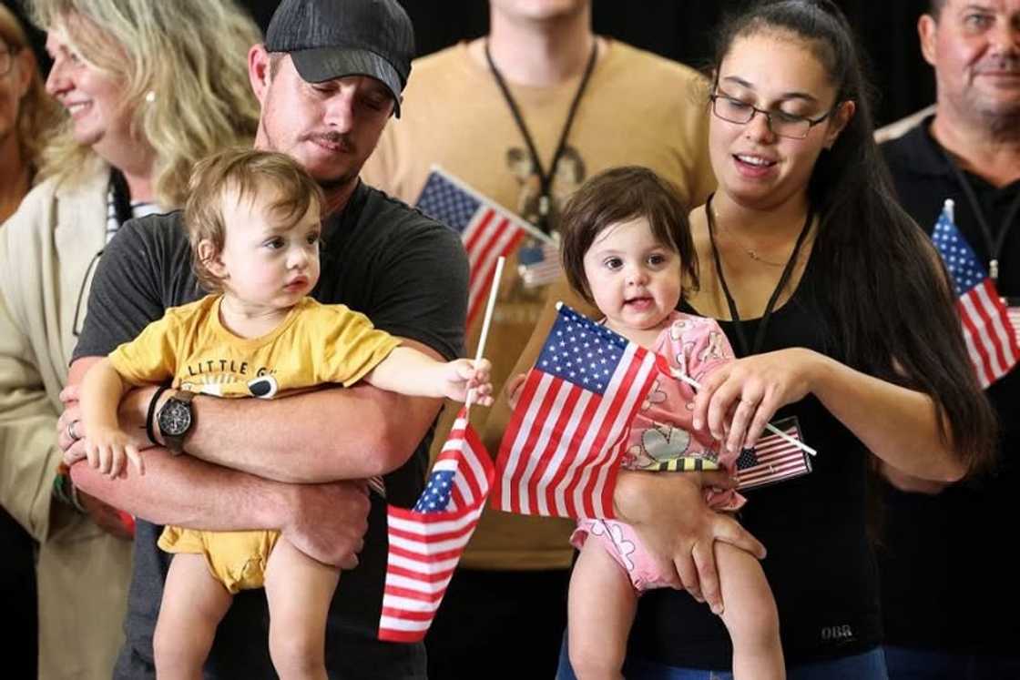 Some South Africans who arrived as 'refugees' are holding American flags.