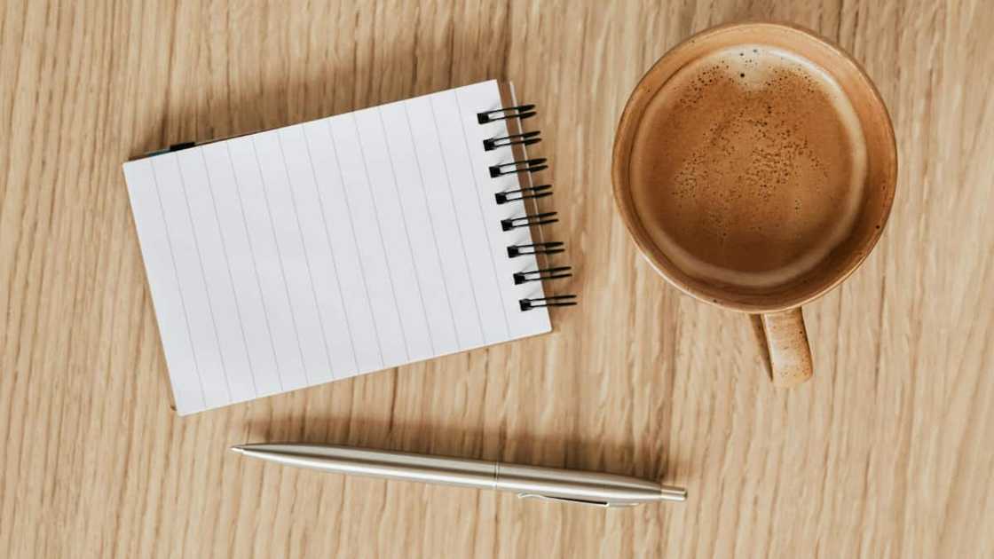 A blank notebook with a pen and coffee. A blank notebook with a pen and coffee.