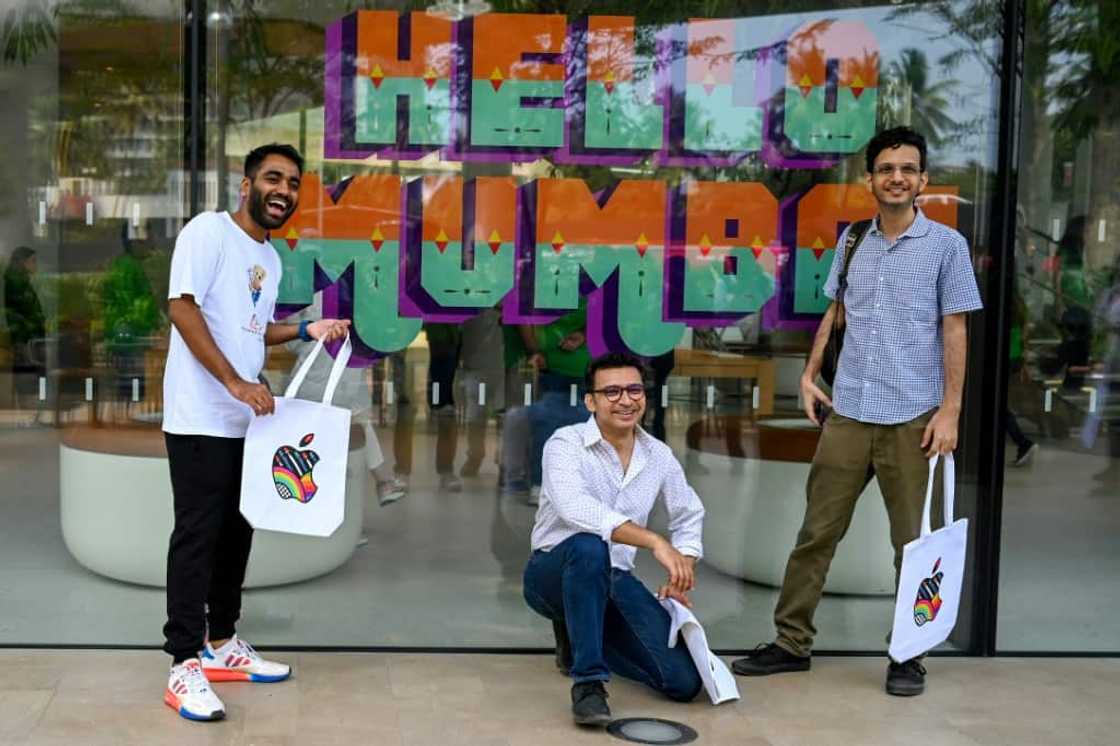 Apple fans pose outside the company's new Mumbai store during a media preview Apple fans pose outside the company's new Mumbai store during a media preview