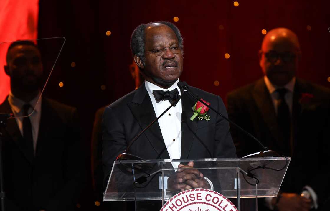 Adebayo Ogunlesi in a black and white suit speaking onstage during Morehouse College 32nd Annual "A Candle In The Dark" Gala