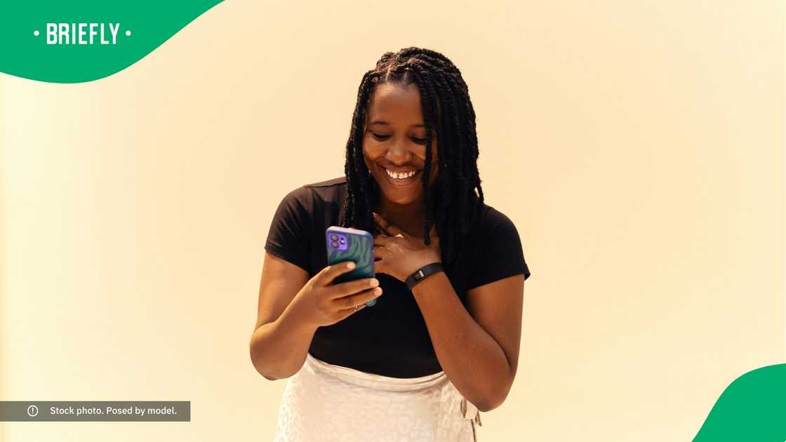 A woman smiling at her phone. A woman smiling at her phone.