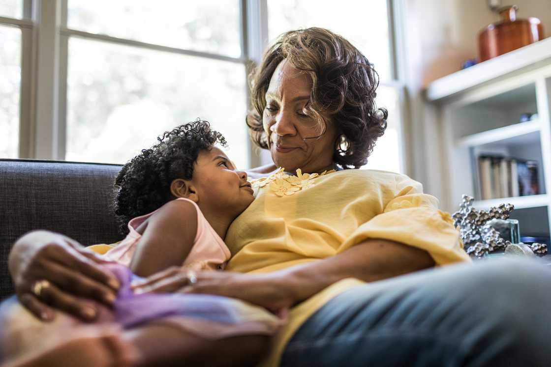 A senior woman cuddling with a young girl
