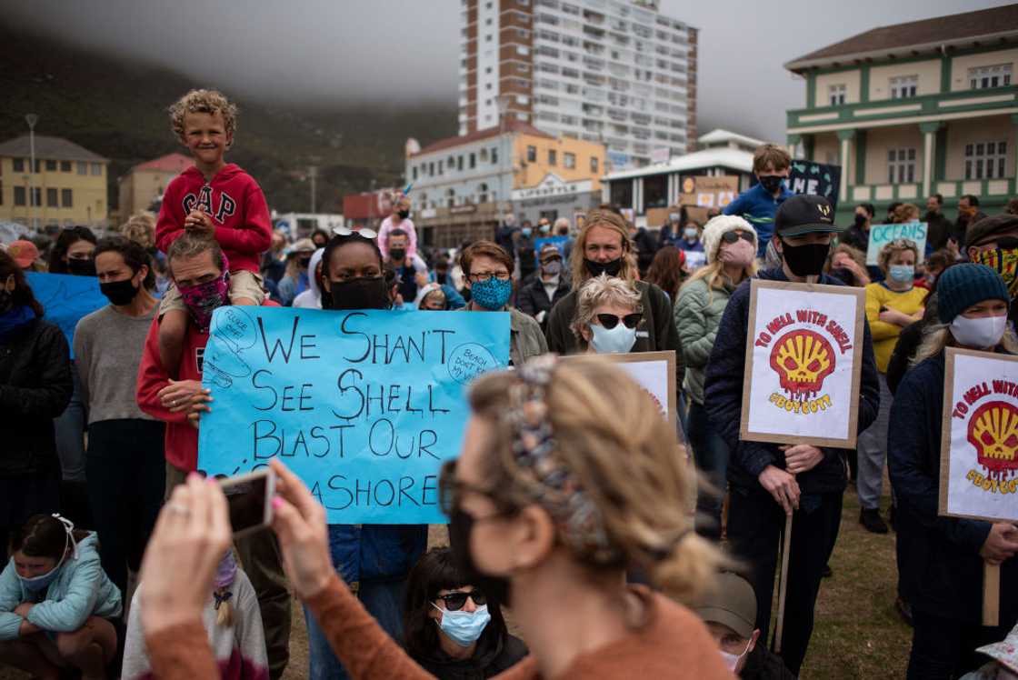 Hundreds of people take part in a protest against the plan by Dutch oil company Shell to conduct underwater seismic surveys along South Africa's East coast, at Muizenberg Beach, in Cape Town, on December 05, 2021