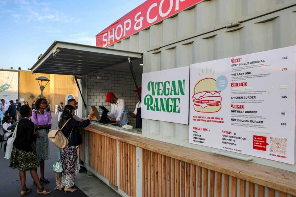 Delegates order from a food stall serving vegan food in addition to beef and chicken at the Sharm el-Sheikh International Convention Centre Delegates order from a food stall serving vegan food in addition to beef and chicken at the Sharm el-Sheikh International Convention Centre