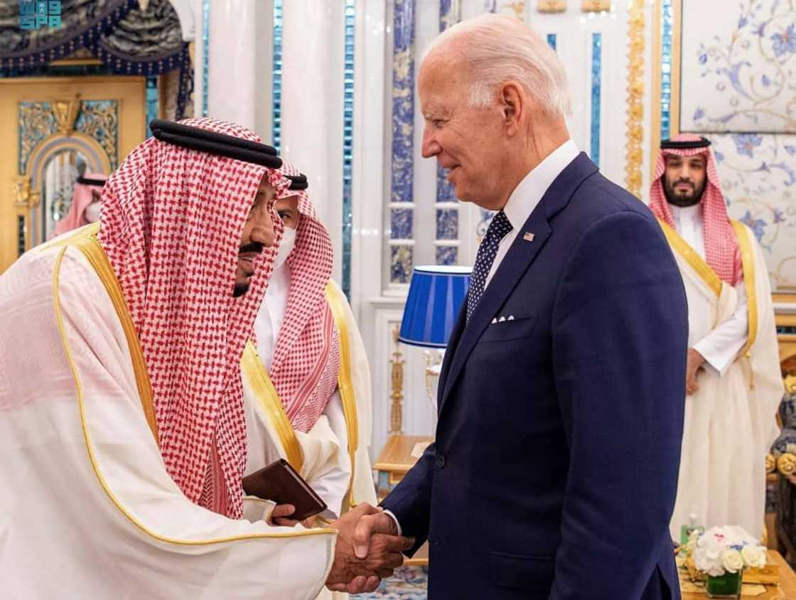 This handout aerial image released by the Saudi press Agency (SPA) shows (L to R) Saudi Arabia's King Salman receiving US President Joe Biden as Crown Prince Mohammed bin Salman looks on behind