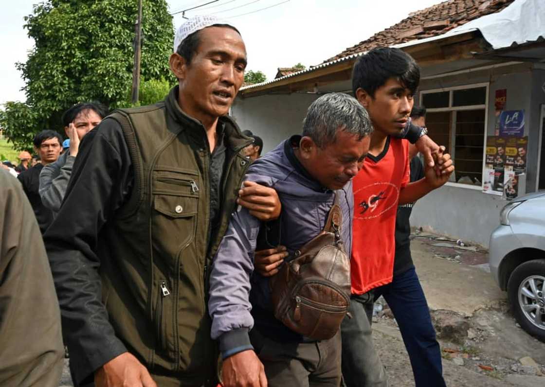 A tearful man was so heartbroken he had to be held up by two of his friends A tearful man was so heartbroken he had to be held up by two of his friends