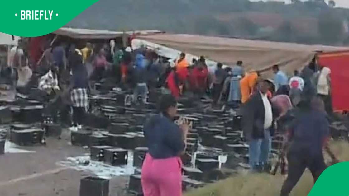A group of people looting handed a black label to passing motorists A group of people looting handed a black label to passing motorists
