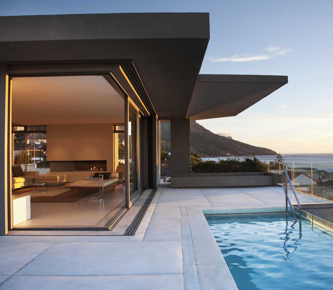 Stock image of a modern living room and patio next to swimming pool